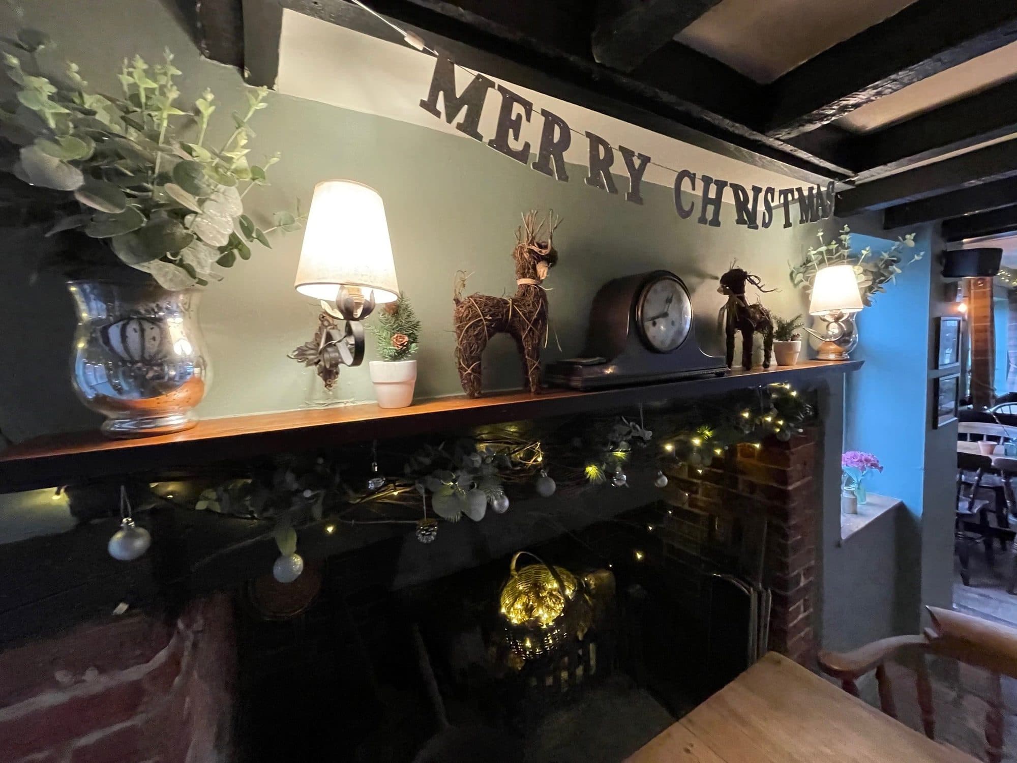 Christmas mantel at The Windmill Inn — Merry Christmas banner, reindeer and fairy lights