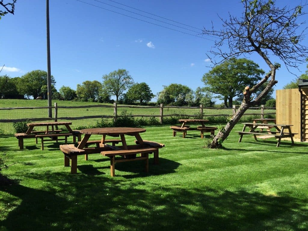 Picnic tables on the lawn looking out to open fields