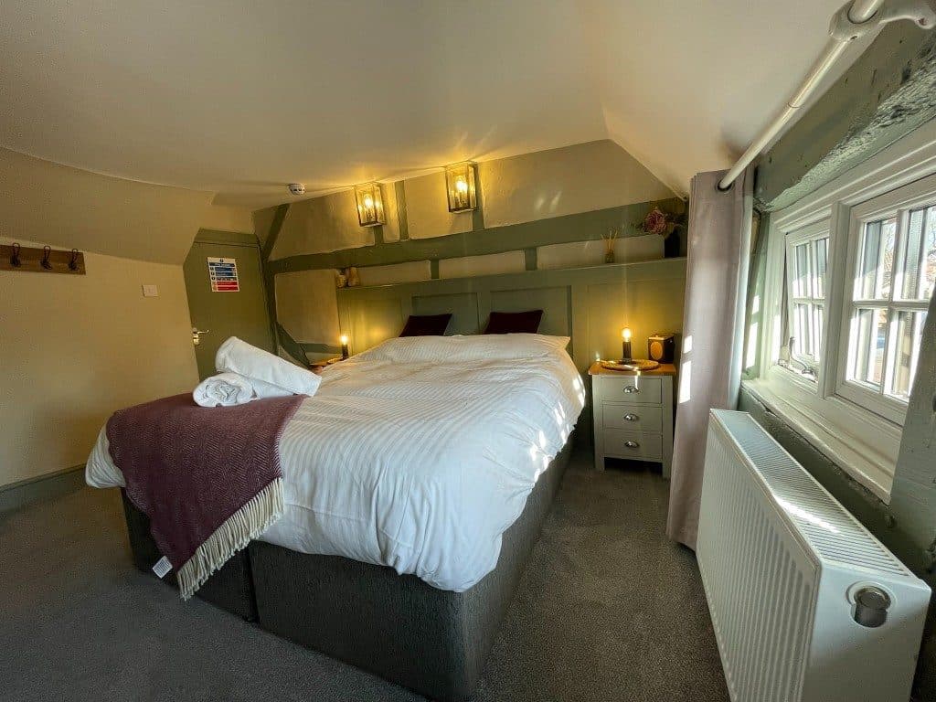 En-suite bedroom with desk, mirror and soft green walls