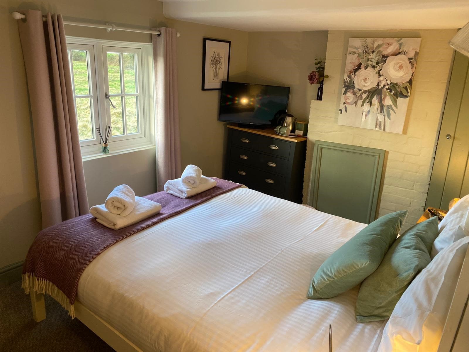 Bedroom with countryside window and floral artwork